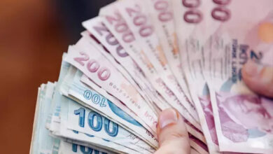 Fotoğrafta bir kişinin elinde bulunan birçok 200 Türk lirası ve 100 Türk Lirası kağıt paralar var.