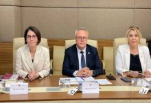 Bu görselde, Türkiye Büyük Millet Meclisi’nde (TBMM) düzenlenen bir komisyon toplantısında üç milletvekili yer alıyor. Ortam resmi ve ciddi bir toplantı salonunu andırıyor. Masada “Milletvekili” yazılı kartlar, numaralandırılmış koltuklar, evraklar, su bardakları ve belgeler dikkat çekiyor.