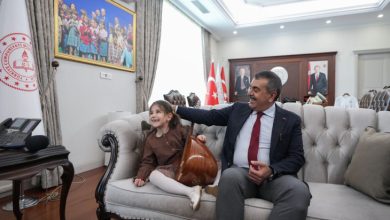 Görme engelli Nil Korkmaz bağlama tutarak Milli Eğitim Bakanı Yusuf Tekin ile koltukta oturuyor.