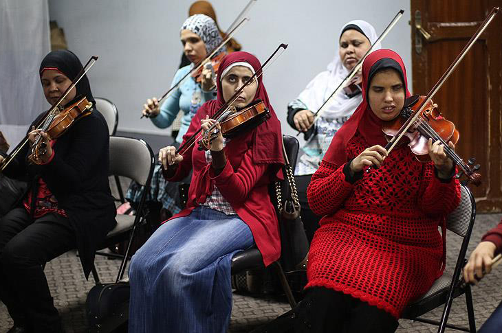 Görme Engelli Kadın Orkestra grubu keman çalıyor.