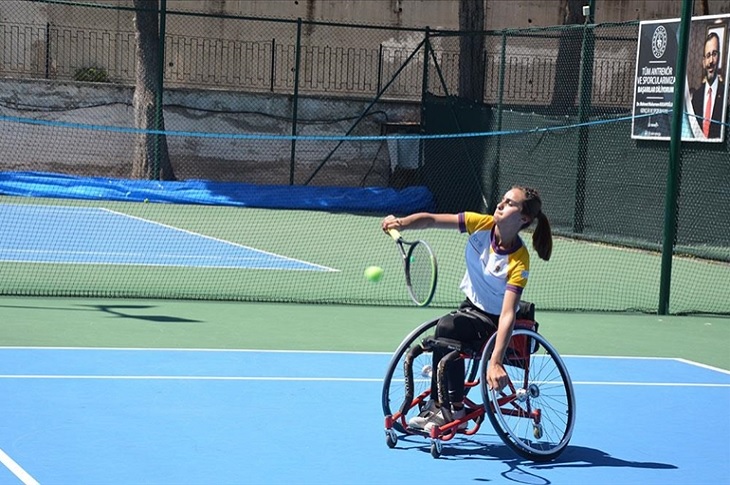 Milli Tenisçi, tenis sahasında raketi ile antrenman yapıyor.