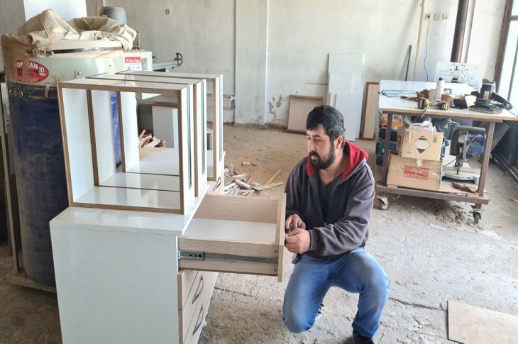 KOSGEB desteği ile işyerini açan Erhan Uslu, ürettiği mobilya ürününü inceliyor.
