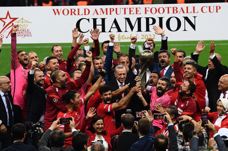 Cumhurbaşkanı Recep Tayyip Erdoğan'ın takdim ettiği Dünya Kupasını Ampute Milli Futbol Takımı sporcuları havaya kaldırıyor.