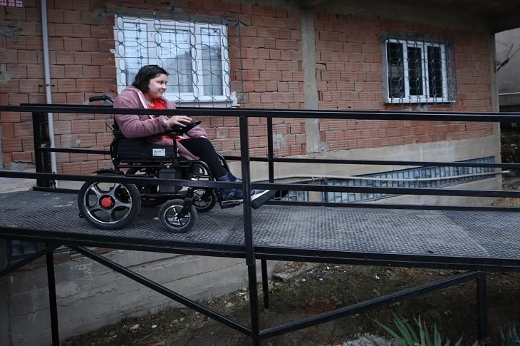 Medine Nur, ev kapısının önüne yapılan metal köprü üzerinden akülü aracıyla geçiyor.