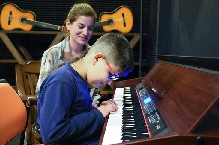 Piyano çalan Ertuğrul ve yanındaki annesinin yüzündeki sevinç objektife yansıyor.