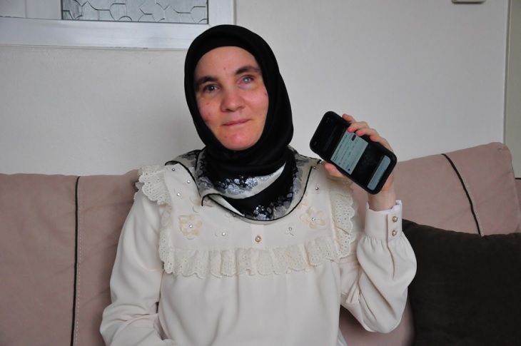 Üniversitesini tamamlayan Hülya Gül, elindeki cep telefonu ile birlikte objektife yansıyor.