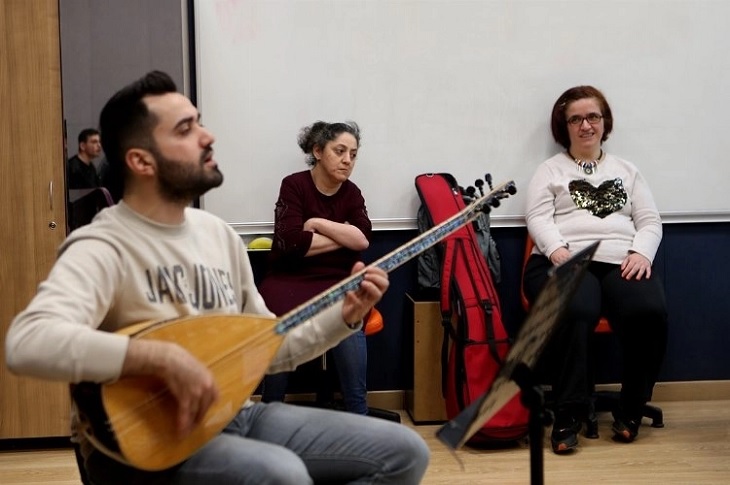 Bağlama çalan hocalarını dinleyen engelli bireyler objektife yansıyor.