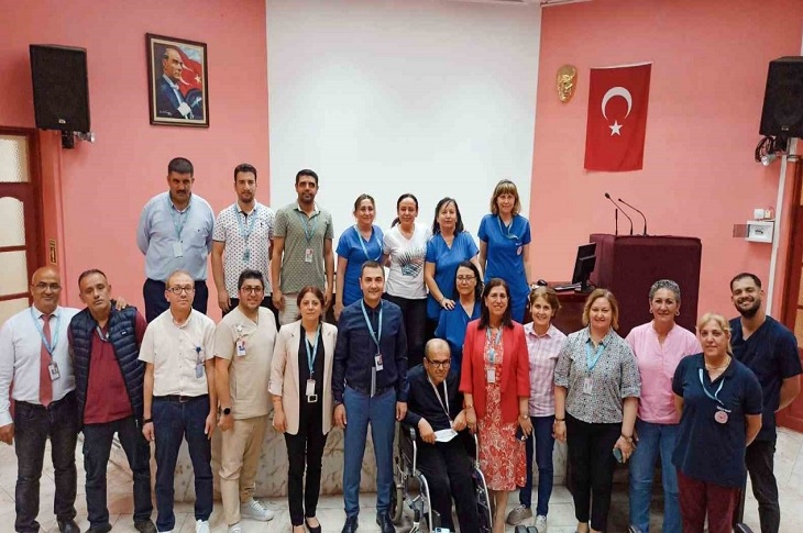 Hastane yöneticilerinin, engelli personellerle birlikte olduğu bir toplu hatıra resmi objektife yansıyor.