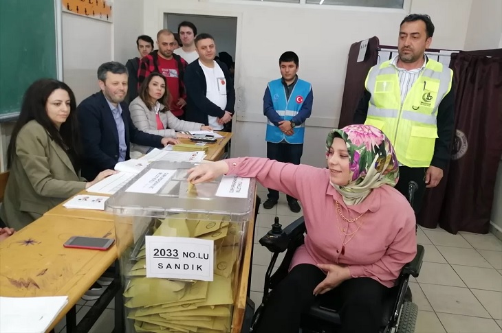 Oyunu sandığa atan bir akülü sandalyeli birey objektife yansıyor.