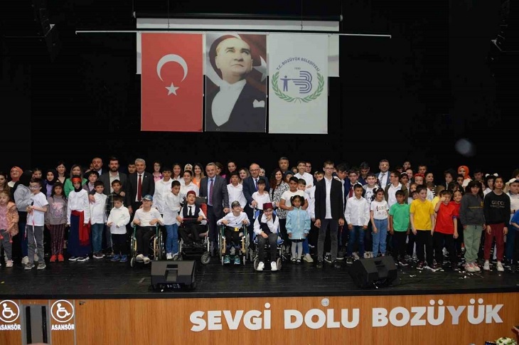 Yetkililerin, sahnede çok sayıda engelli çocukla beraber çekilen toplu hatıra resmi objektife yansıyor.