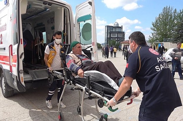 Sağlık görevlileri tarafından, sedye ile ambulans aracına bindirilen yaşlı bir seçmen objektife yansıyor.