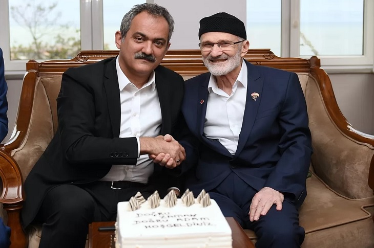 Bakan Mahmut Özer ve Kıbrıs Gazisi Ömer Özkurt'un el sıkışarak çektikleri bir hatıra resmi objektife yansıyor.