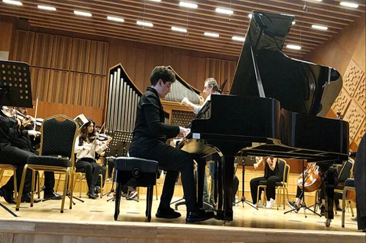 Piyanist Koral Erdeniz, senfoni orkestrası konserinde piyano çalıyor.