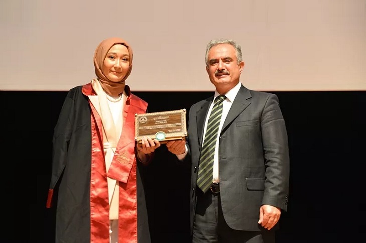 Belgesini hocasından teslim alan Emine, hocasıyla birlikte objektife yansıyor.