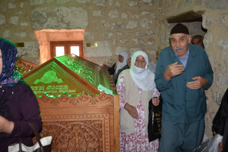 Türbe ziyaretini gerçekleştiren yaşlı bireyler objektife yansıyor.