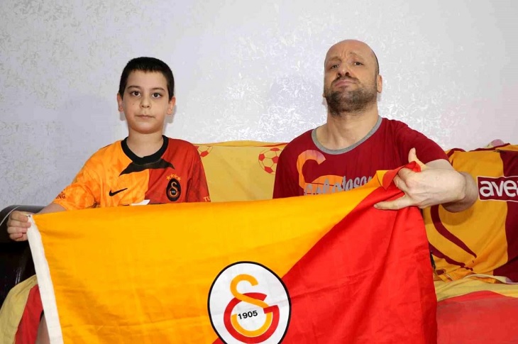 Galatasaray forması giyen Murat İçli ve kardeşi, beraber açtıkları Galatasaray bayrağı ile birlikte objektife yansıyor.
