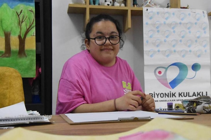 Hilal Kurtkara, masa başında çizim öncesi bir görüntüsü ile objektife yansıyor.