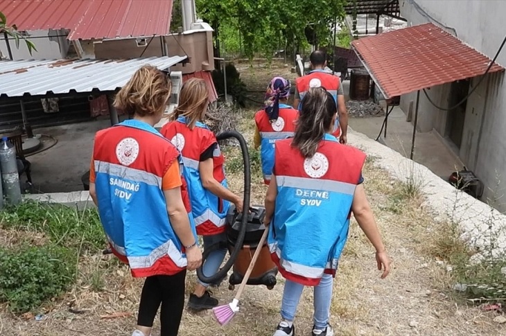 İhtiyaç sahibi adrese doğru yürüyen bir grup görevli objektife yansıyor.