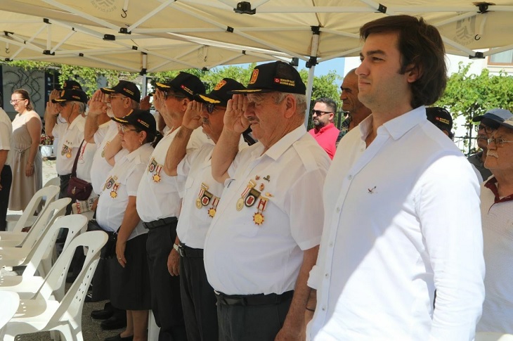 Saygı duruşu sırası selam duruşunda olan katılımcı gaziler objektife yansıyor.