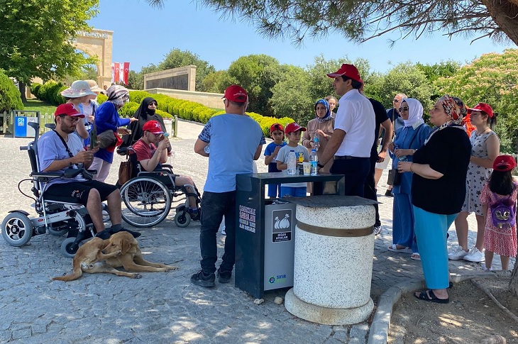 Gezi alanında gölgelik alanda mola veren engelli bireyler objektife yansıyor.
