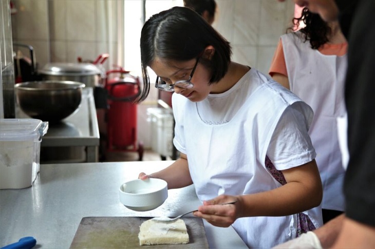 Mutfakta çalışan bir özel gereksinimli birey objektife yansıyor.