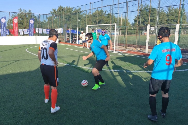 Gözleri bağlı şekilde futbol karşılaşması yapan iki takım oyuncuları objektife yansıyor.