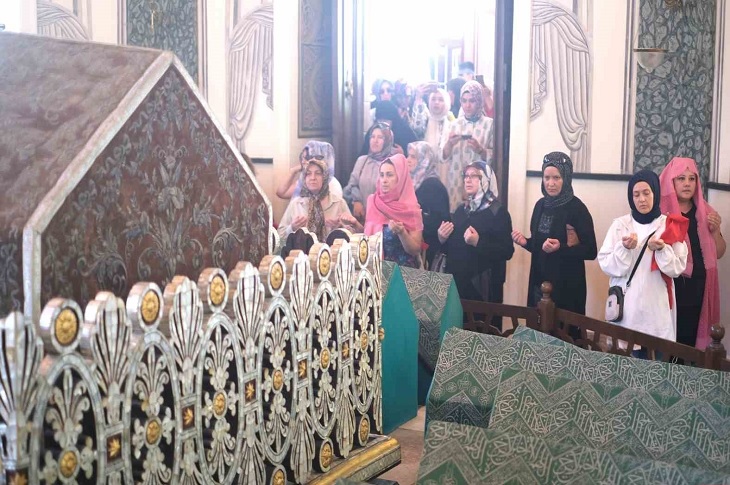 Türbe içerisinde dualar eden çok sayıda ziyaretçi objektife yansıyor.