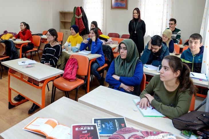 Sınıftaki sıralarda dersi takip eden özel gereksinimli bireyler objektife yansıyor.