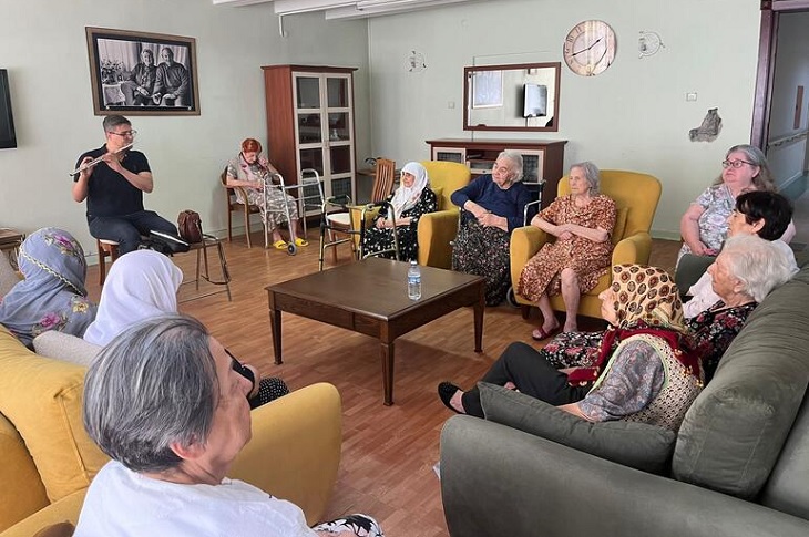 Müzik öğretmeni Burak Can Kabaardıç'ın konserini dinleyen huzurevi sakinleri objektife yansıyor.