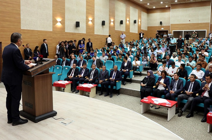 Sağlık Bakanı Fahrettin Koca'nın çok sayıda katılımcı karşısında, kürsüde konuşma yaptığı ana dair bir resim objektife yansıyor.