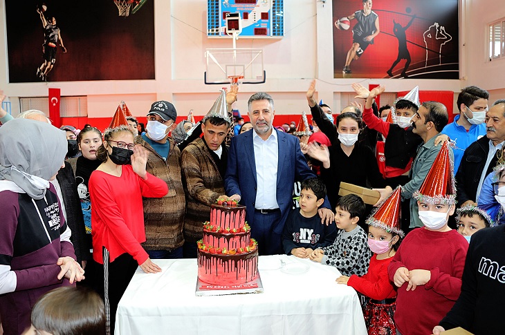 Kapalı spor salonunda yapılan doğum günü partisine katılan çok sayıda engelli çocuğun toplu hatıra resmi objektife yansıyor.