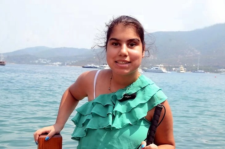 Helen, arkasındaki dağ ve deniz manzarasıyla birlikte objektife yansıyor.