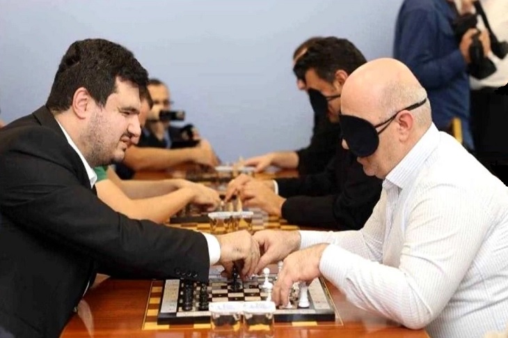 Haberi temsilen, ayrı masalarda satranç oynayan görme engelli bireyler objektife yansıyor.