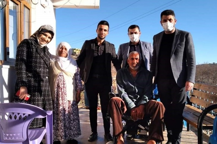 Yetkililerin, akülü aracı teslim ettikleri aile ile birlikte çektikleri bir hatıra resmi objektife yansıyor.