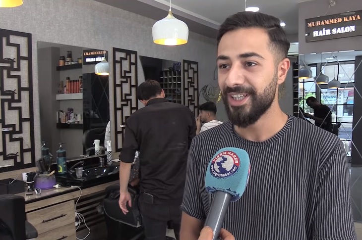 Muhammet Kaya'nın, işyerine gelen haber muhabirinin sorularını yanıtladığı ana dair bir görüntü objektife yansıyor.