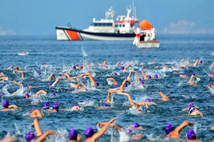 Boğazda yüzen çok sayıda sporcunun denizde kulaç attığı ana dair bir görüntü objektife yansıyor.