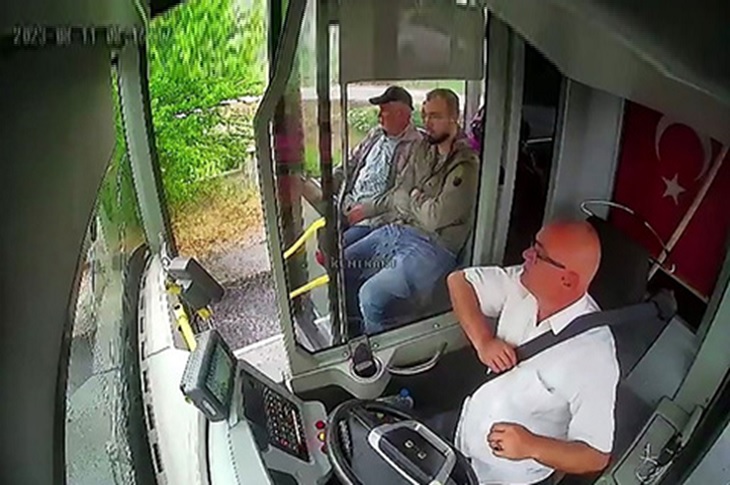 Direksiyon başındaki şoför ve ön koltukta oturan iki yolcu objektife yansıyor.