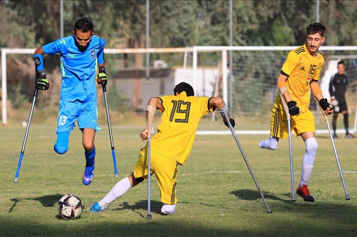 Sahadaki futbol karşılaşmasında iki takım oyuncusunun karşı karşıya geldiği bir görüntü objektife yansıyor.