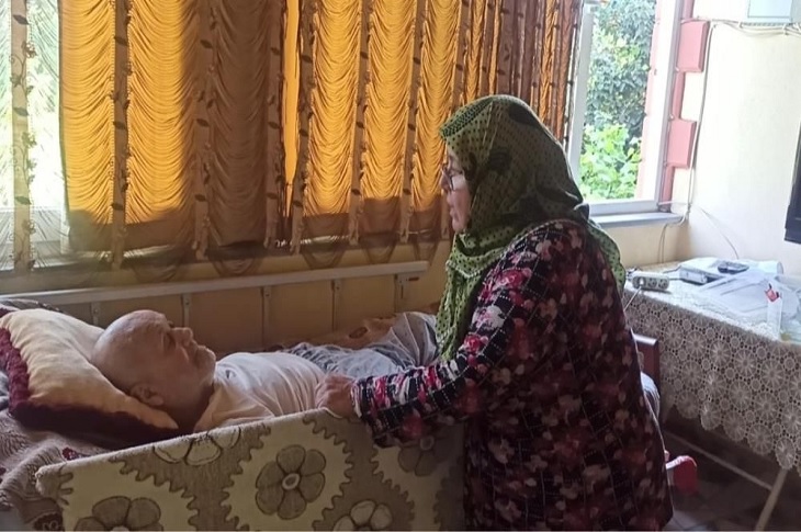 Alzheimer hastası yatalak kocasının başucundan ayrılmayan vefalı kadın objektife yansıyor.