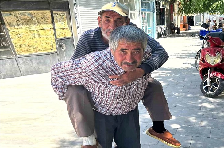 Hatem Doğan, sırtında taşıdığı abisiyle birlikte objektife yansıyor.