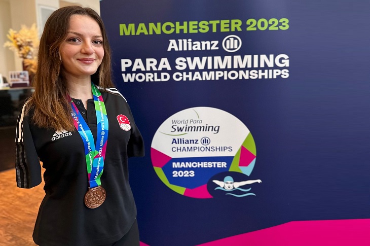 Başarılı yüzücü Sümeyye Boyacı, boynundaki bronz madalya ile birlikte objektife yansıyor.