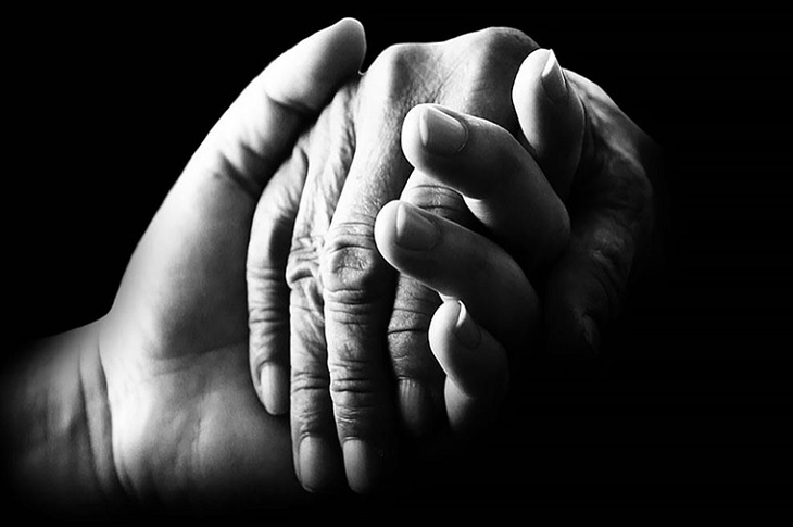 Haberi temsilen, bir yaşlı eli tutan genç el resmi objektife yansıyor.