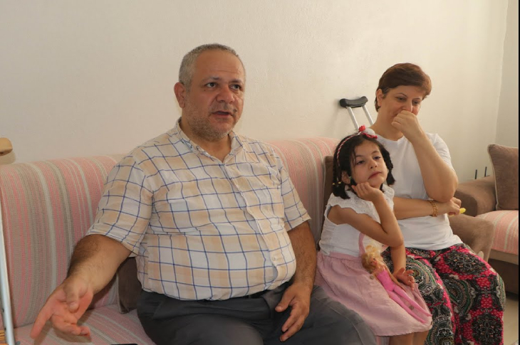 Soldan sağa doğru Faruk Malak, kız çocuğu ve Seher Malak yan yana koltukta oturuyor.