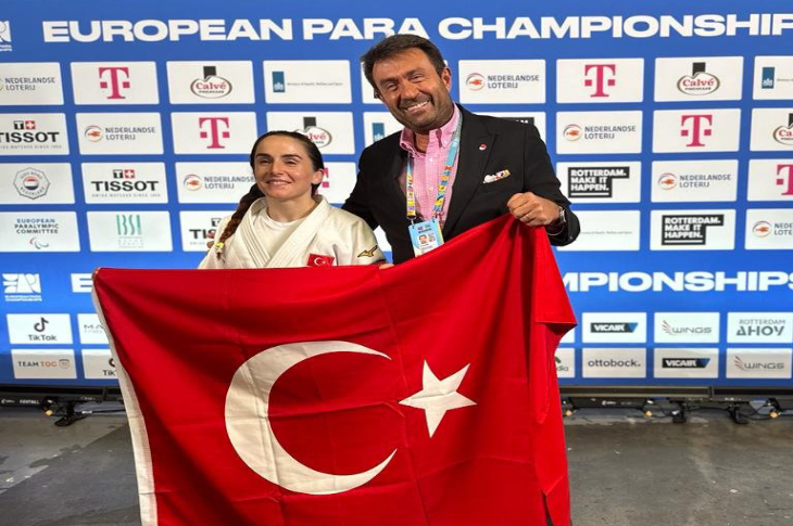 Türkiye Milli Paralimpik Komitesi Başkanı Murat Aksu ve para judocu Döndü Yeşilyurt Türk bayrağı tutuyor.