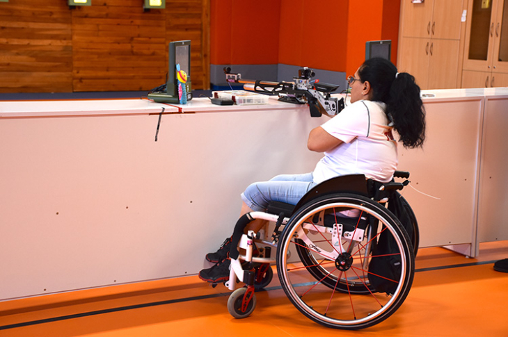 Suzan Çevik antrenman salonunda spor tabancası ile atış yapıyor.