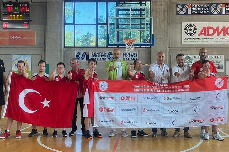 Türk bayrağı açan Down Sendromlu Milli Basketbol Takımı oyuncuları objektife yansıyor.
