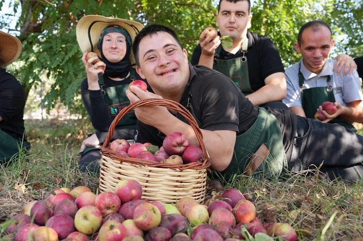 Özel gereksinimli bireyler hasadını yaptıkları elmalarla birlikte objektife yansıyor.
