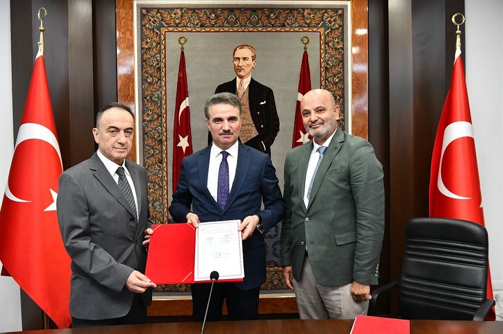 Valilik makam odasında protokolü imzalayan tarafların hatıra resmi objektife yansıyor.