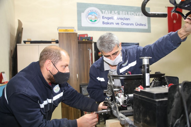 Atölyede engelli aracını tamir eden 2 usta objektife yansıyor.