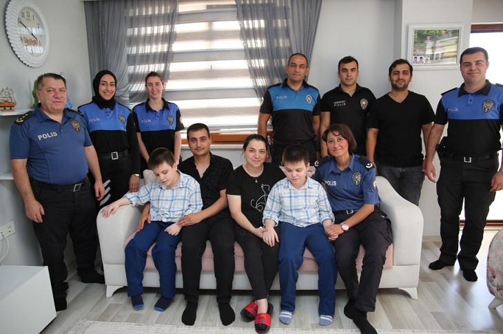 Haneyi ziyaret eden polis memurları, aile sakinleriyle birlikte objektife yansıyor.